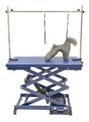 K9 Trailer Rentals A small gray dog stands on the Electric Grooming Table N-109X, a blue adjustable table, secured by two grooming straps attached to an overhead bar.