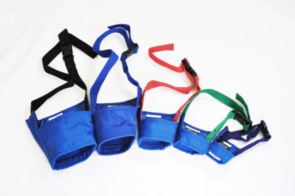 K9 Trailer Rentals Four Quick Muzzle for Dogs in blue fabric, each a different size, are lined up on a white background with adjustable straps in black, red, green, and blue.