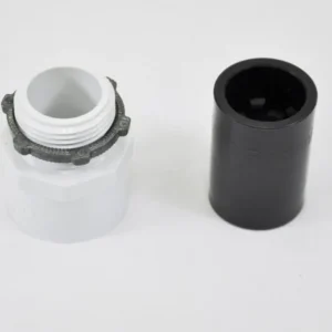 K9 Trailer Rentals A white plastic threaded connector with a gray ring next to a black cylindrical cap, both placed on a plain white surface.