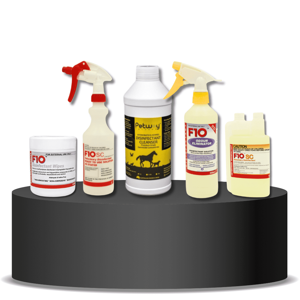 K9 Trailer Rentals Five Trailer Cleaning Bundle products—including wipes, spray bottles, and a liquid cleanser—are displayed on a round, black podium with a white background. The products feature red, yellow, and white labels.
